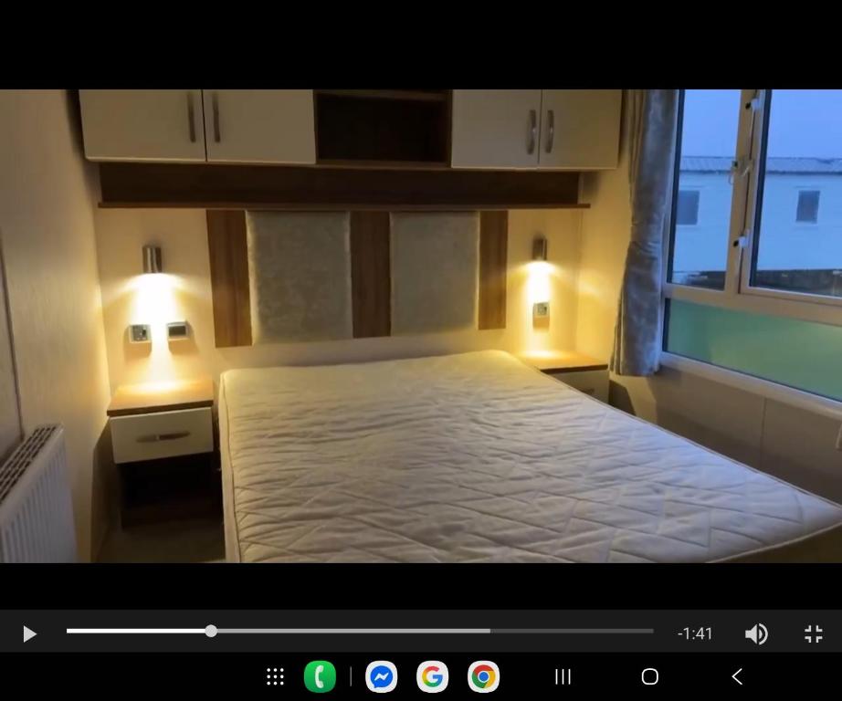 een slaapkamer met een bed met twee verlichting bij Sam's Caravan Hire Coastfield Holiday Village Ingoldmells in Ingoldmells