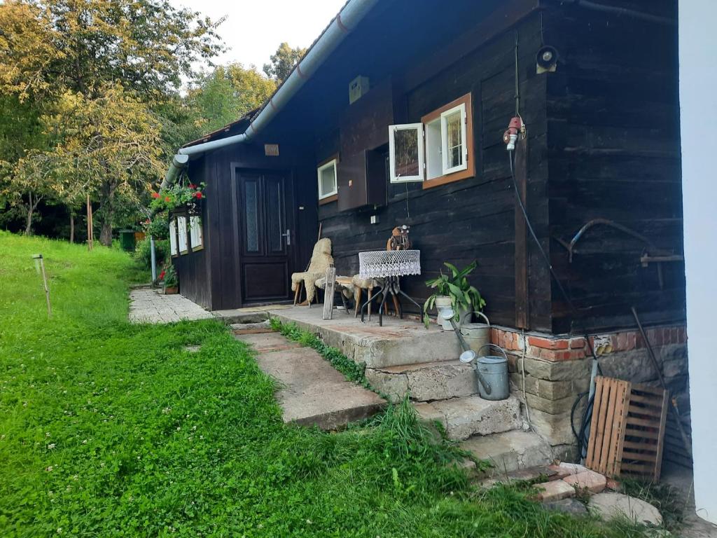 a blue house with a table and chairs in front of it at Chalupa u Josefa in Valašská Polanka