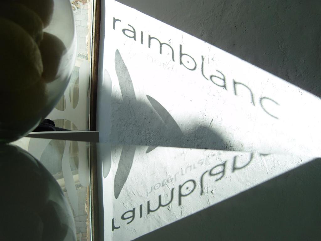 un'ombra di un cartello su una finestra di Hotel Raimblanc a Villargordo del Cabriel