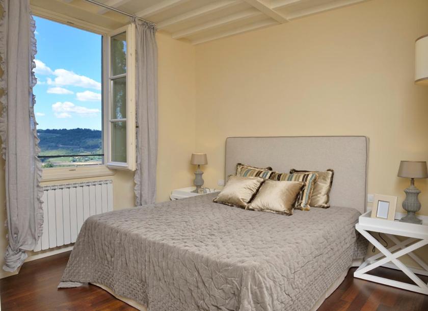 サン・カシャーノ・イン・ヴァル・ディ・ペーザにあるVilla Borri Country Suitesのベッドルーム1室(大きなベッド1台、大きな窓付)