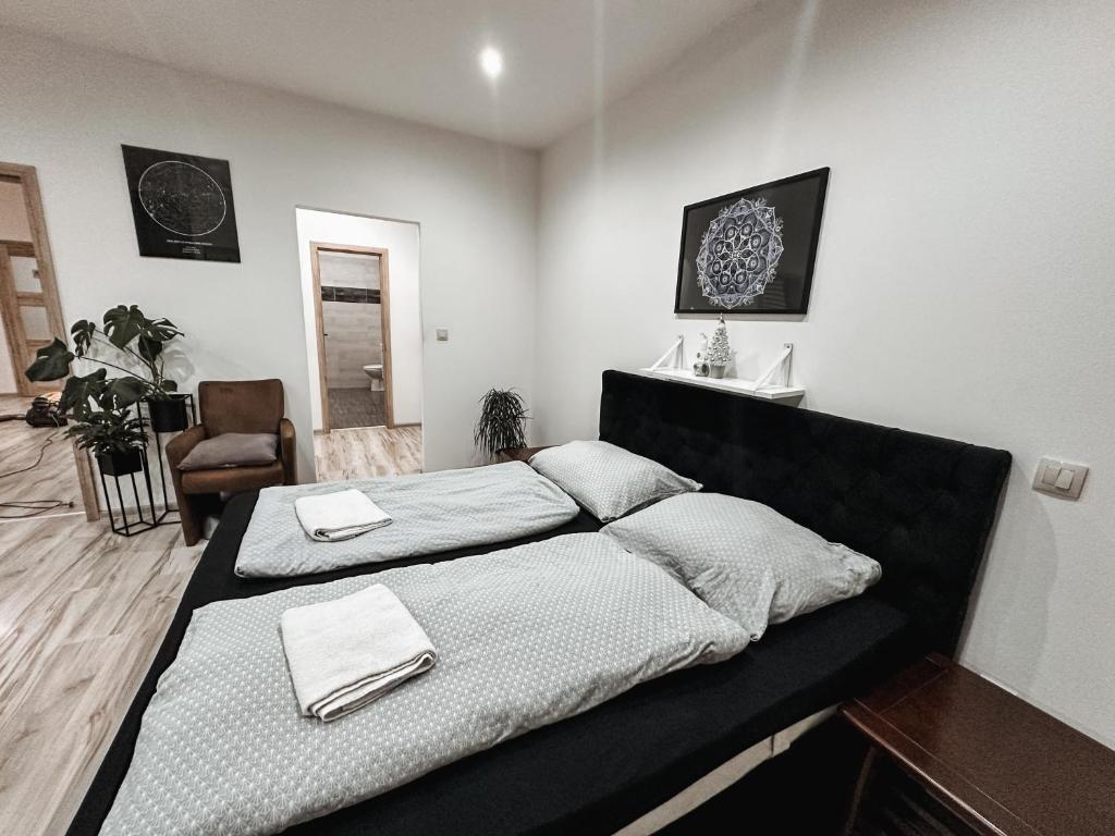 Un dormitorio con dos camas y una silla. en Boutique Residence, en Banská Bystrica