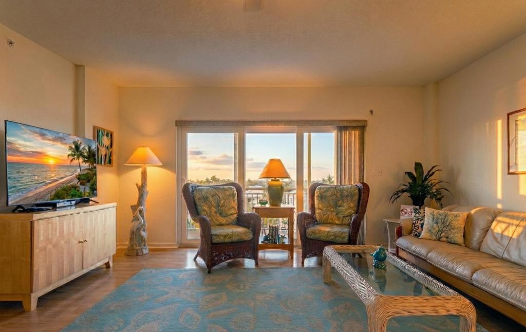 un soggiorno con divano, sedie e TV di Spacious 3BR Beachfront Condo with Balcony & Parking a Satellite Beach