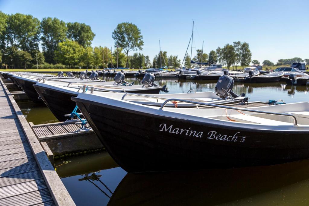 een rij boten geparkeerd in een jachthaven naast een dok bij Oostappen Vakantiepark Marina Beach BV in Hoek