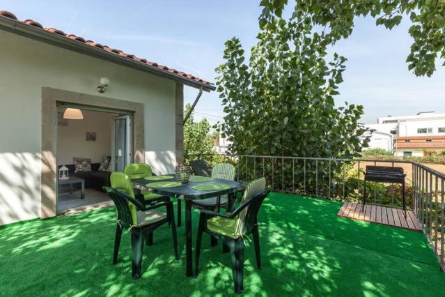 a patio with a table and chairs on the grass at Carvalhosa Apartment in Monte