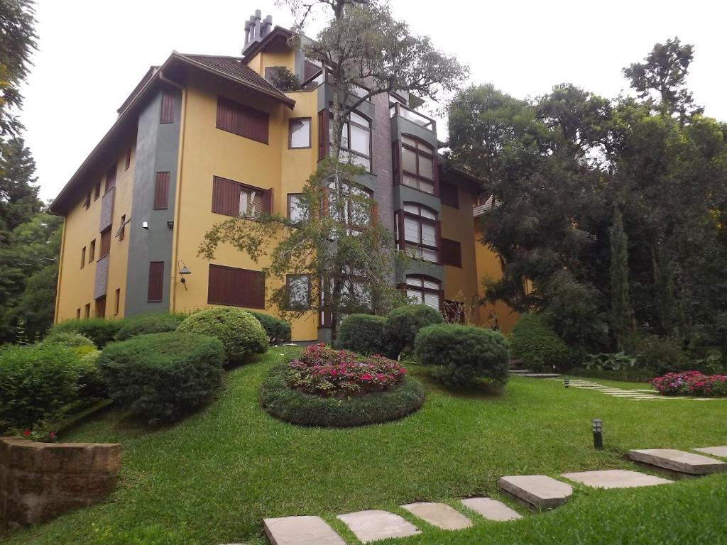 格拉馬杜的住宿－Flat Jardim Primavera，前面有花园的黄色建筑