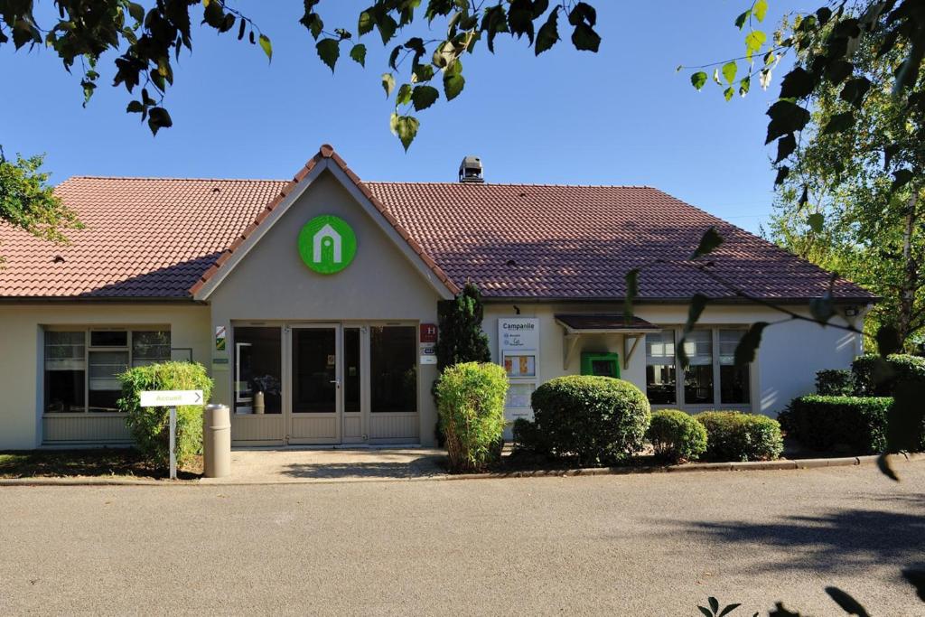 un bâtiment avec un panneau vert dans l'établissement Campanile Bourg-En-Bresse ~ Viriat, à Viriat