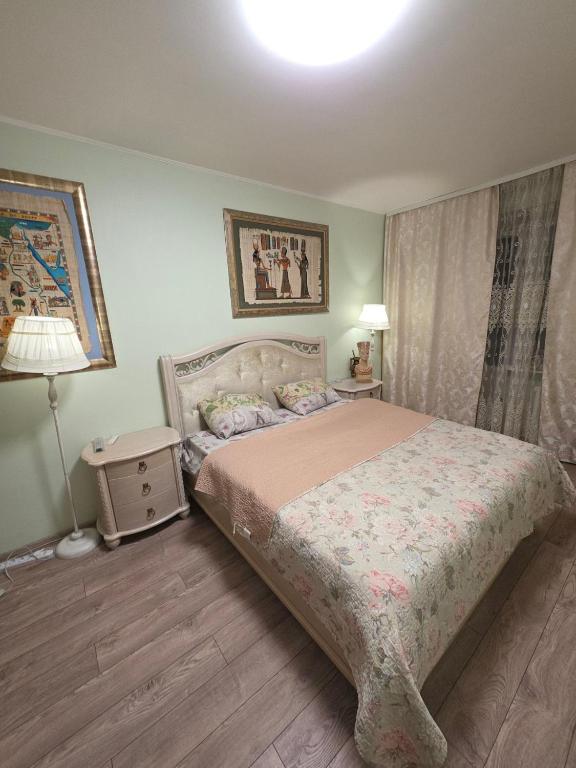 een slaapkamer met een bed en een lamp erin bij House Hotel Apartments 2 in Rivne