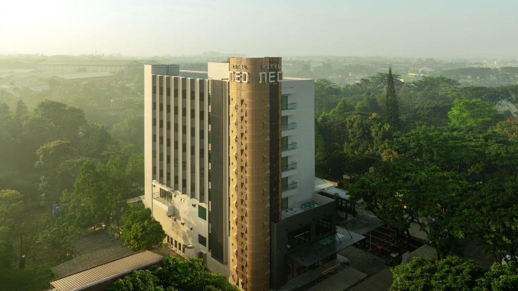 SimparにあるHotel Neo Kota Baru Parahyanganの木立の高い建物の頭上