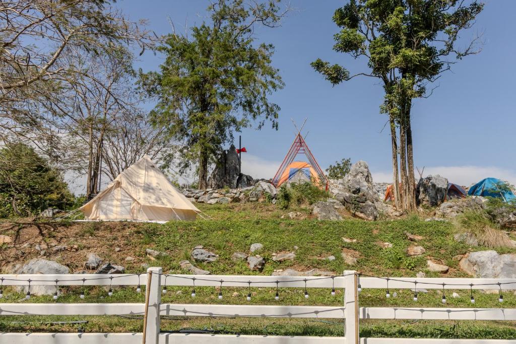 un groupe de tentes sur une colline avec une clôture dans l'établissement Ozone Valley Camp Khaoyai, à Nong Nam Daeng