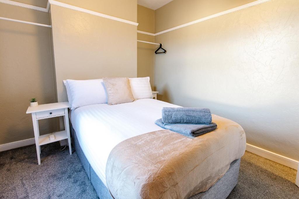 a small bedroom with a white bed and a table at The Nines in Bangor