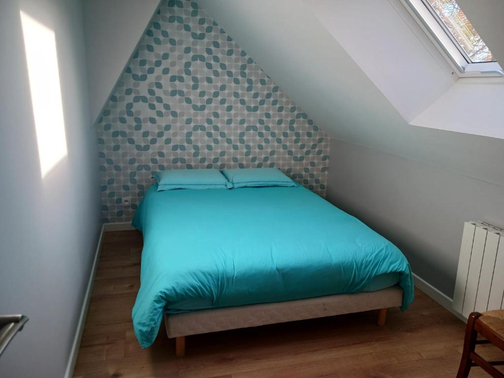 een kleine slaapkamer met een bed op zolder bij Lila in Souillé