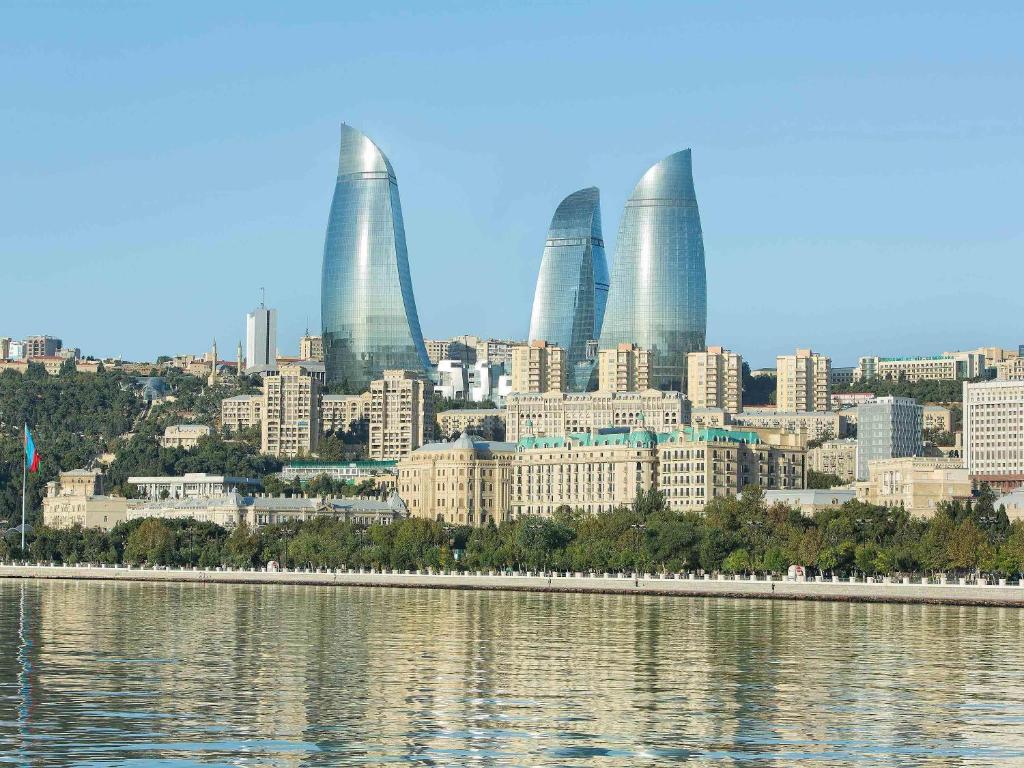 uma vista para uma cidade com edifícios altos e água em Fairmont Baku, Flame Towers em Baku