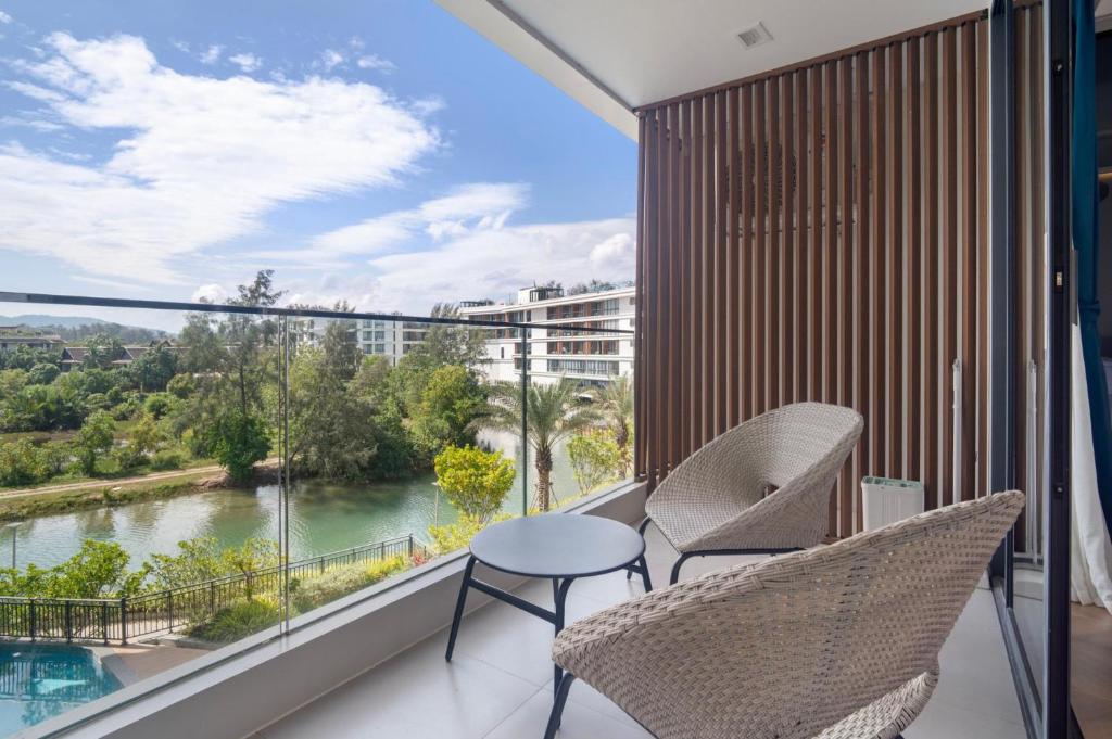 a balcony with chairs and a view of a river at Premier Pool View Studio 348 KoraResort in Layan Beach
