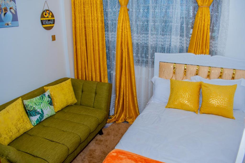 a living room with a bed and a couch at Delsy Stays in Ruaka
