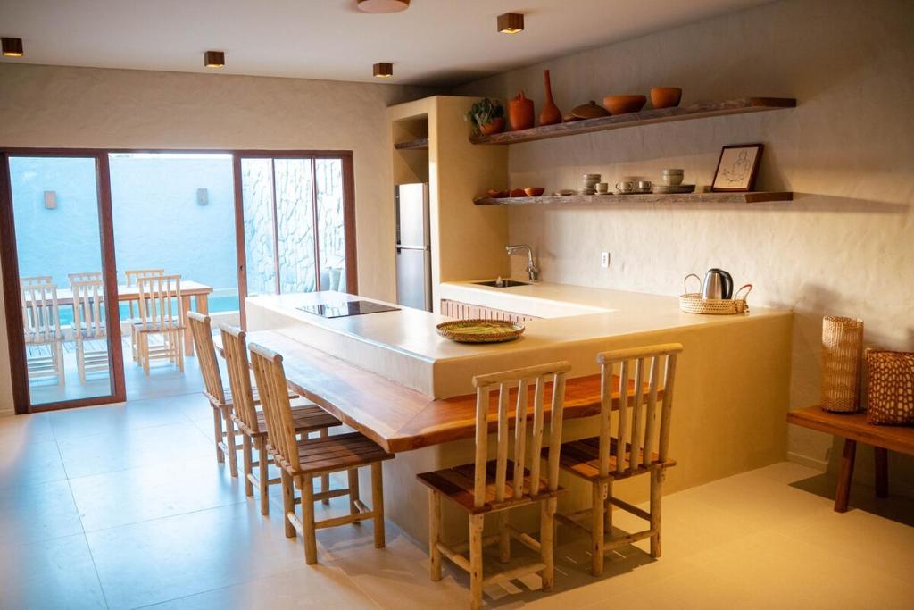 una cucina con un grande tavolo e sedie in legno di Casa Brisa - Villa Vento a Camocim