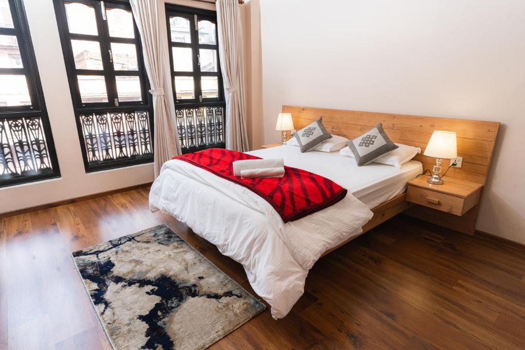 a bedroom with a bed with a red blanket at Maitreya Homestay in Pātan