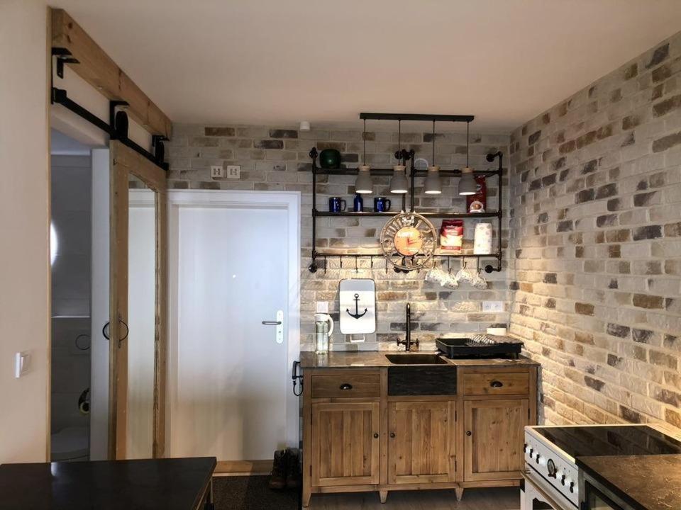 una cucina con bancone e muro di mattoni di Panoramic Sierksdorf Meer Loft a Hansaland