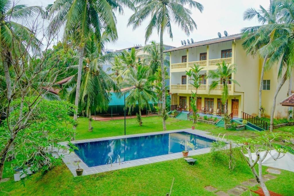 una vista exterior de un complejo con piscina en Muthumuni Ayurveda River Resort, en Aluthgama