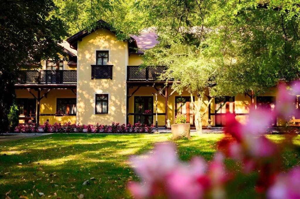 uma casa com flores em frente em Forster Vadászkastély és Szálloda em Bugyi