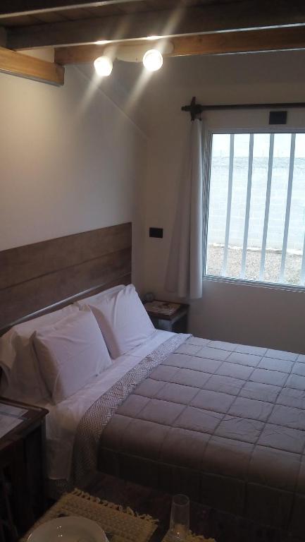 Un dormitorio con una cama grande y una ventana en El Pueblo Aparts - Rada Tilly in 