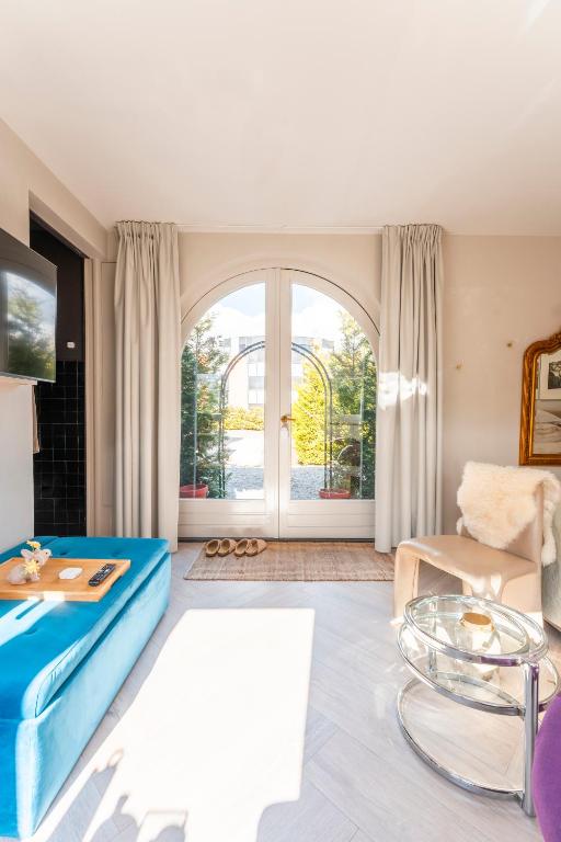 a living room with a blue couch and a table at The Gentle Arch Schiphol Amsterdam in Aalsmeer