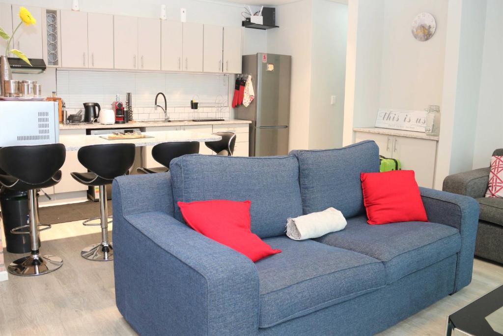 eine blaue Couch mit zwei roten Kissen in der Küche in der Unterkunft Lazarett Loft Modern Apartment in Windhoek