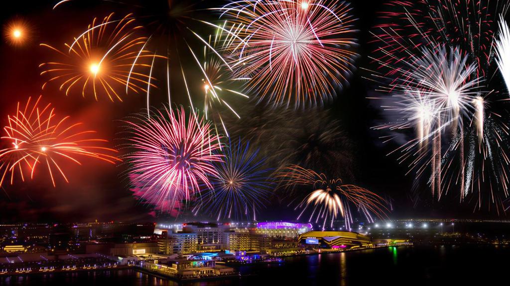 un grupo de fuegos artificiales explotando en el cielo sobre una ciudad en Yas Amazon - Stylish 1BR Apartment on Yas Island 8 Minutes From Yas Island Fireworks, en Abu Dabi
