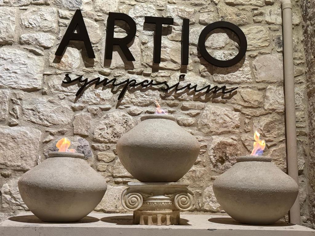 two vases with fires in them in front of a stone wall at ELINN traditional suits in Kathikas