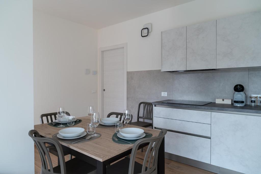 カスティオーネ・デッラ・プレゾラーナにあるBratto Relax Apartmentsの木製のテーブルと椅子が置かれたキッチン