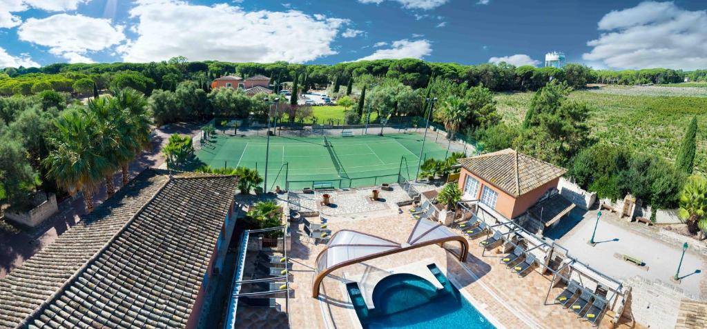 eine Luftansicht eines Tennisplatzes mit Tennisplatz in der Unterkunft L'Oliveraie de Paul in Aigues-Mortes