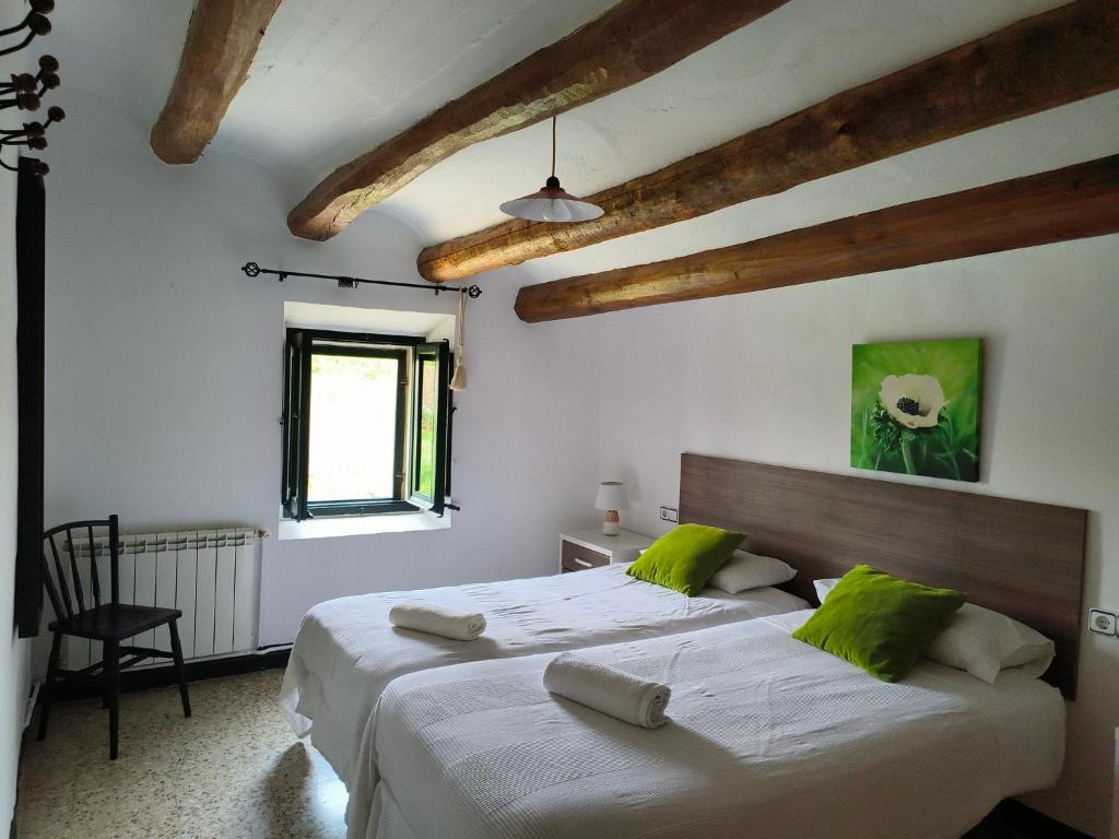 two beds in a room with wooden beams at Can Teulera in San Martín Sarroca
