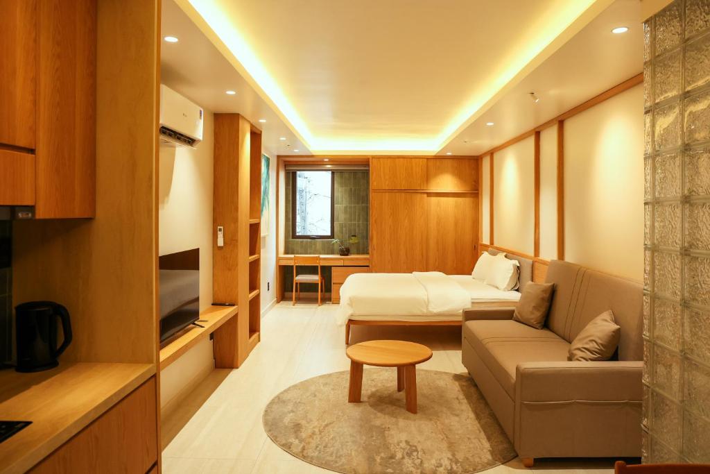 a room with a couch and a bed and a table at AN Studio VVT in Ho Chi Minh City