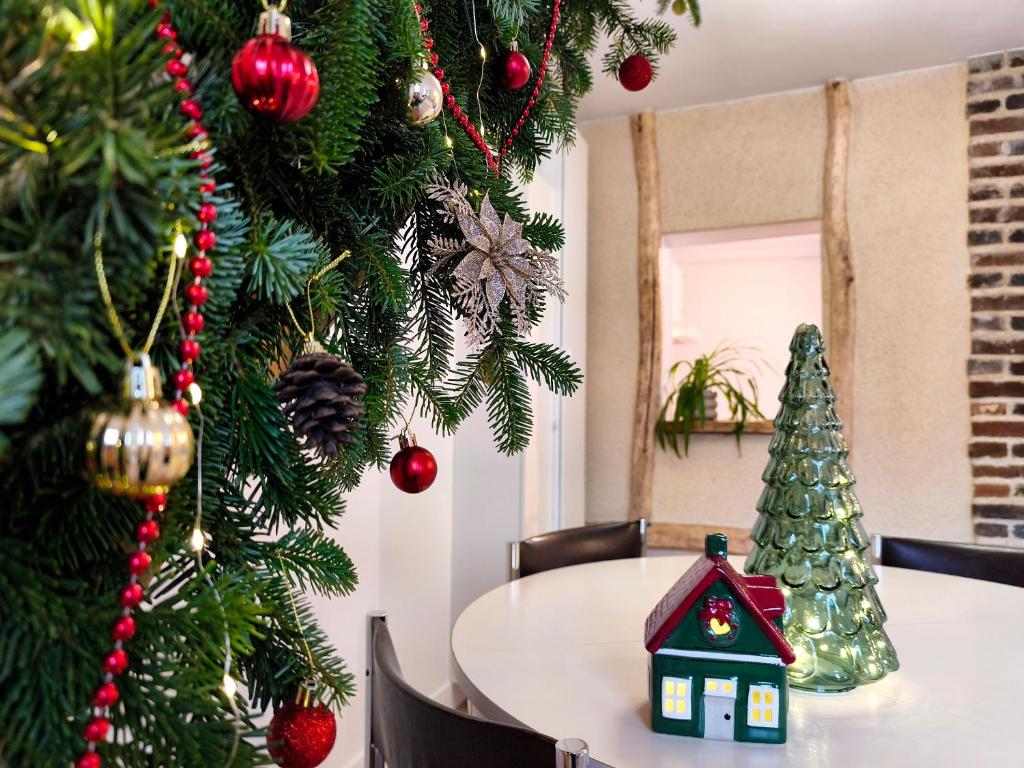 Maison normande en centre ville في Breteuil-sur-Iton: غرفة طعام مع شجرة عيد الميلاد وطاولة