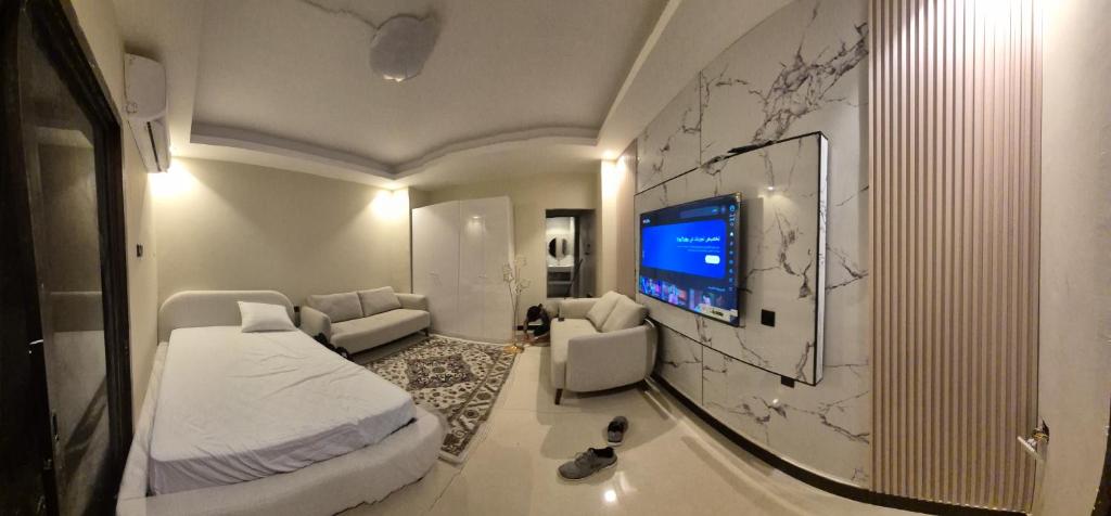 ein Hotelzimmer mit Bett und Fernseher in der Unterkunft ميرا للشقق الفندقية in al-Ain