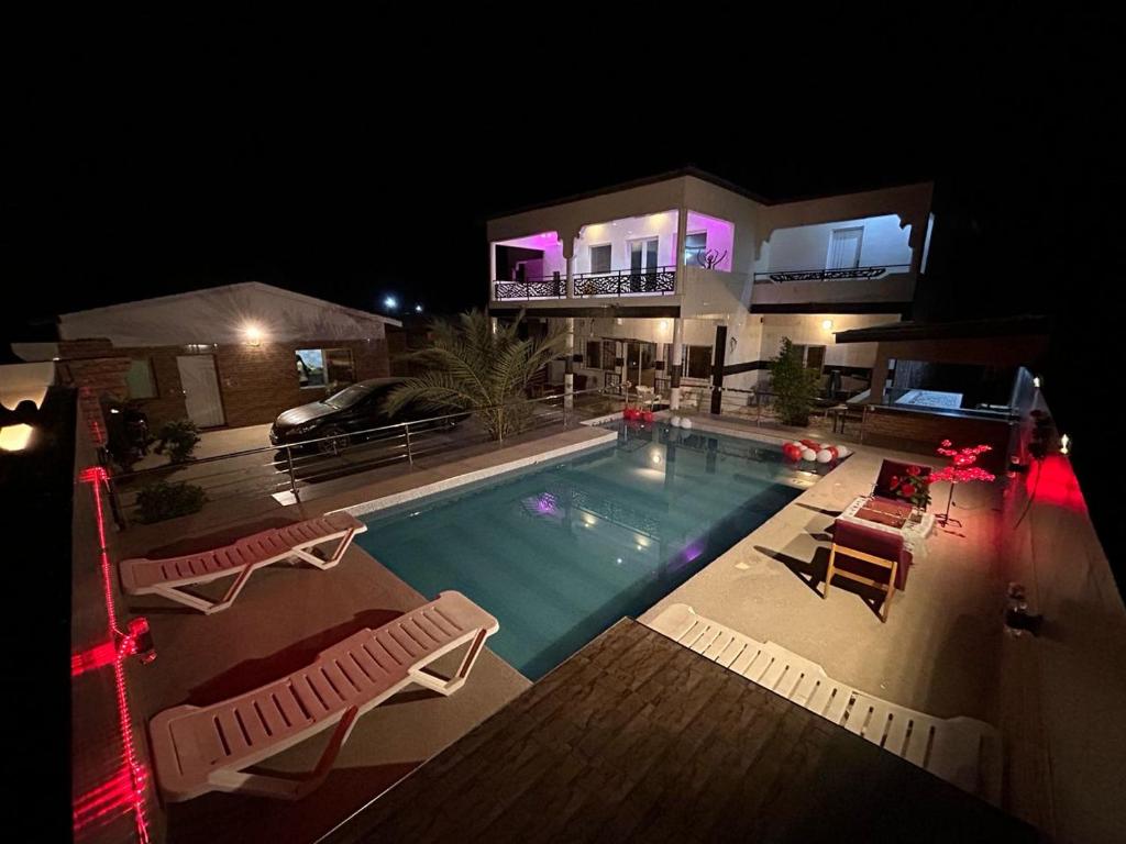 uma casa com piscina à noite em Mdf Saloum em Poundiougne