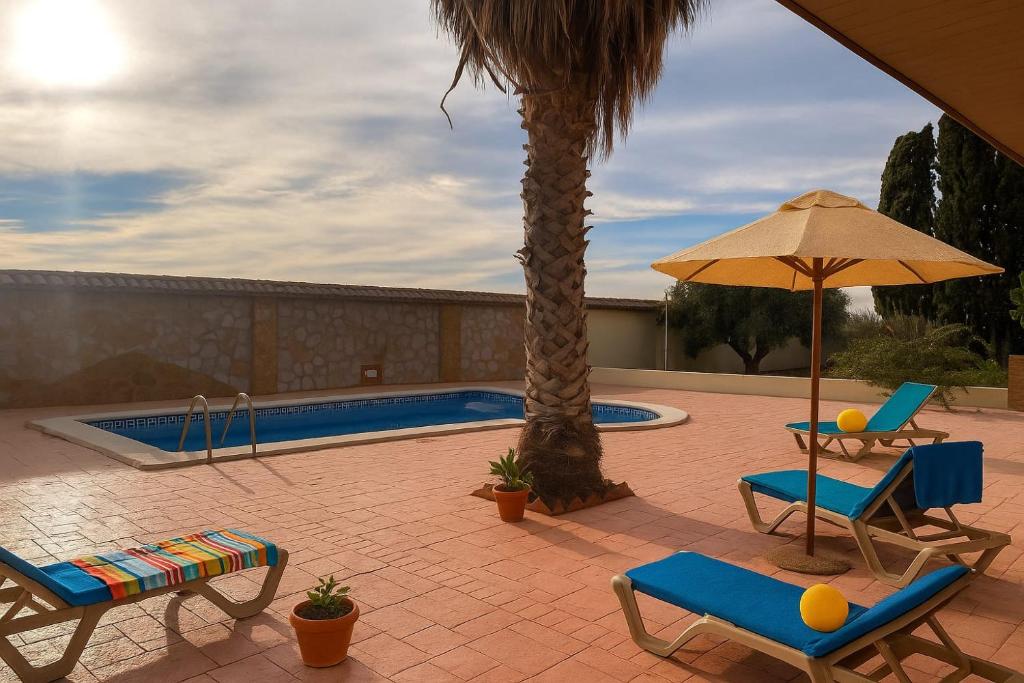 patio con sedie, ombrellone e piscina di La Casona del Olivo a Torre-Pacheco