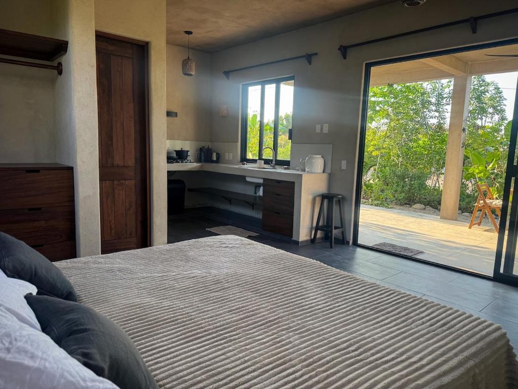 Schlafzimmer mit einem Bett und Blick auf einen Innenhof in der Unterkunft Quiet Oceanside Casita Private Kitchen & Bath in Troncones