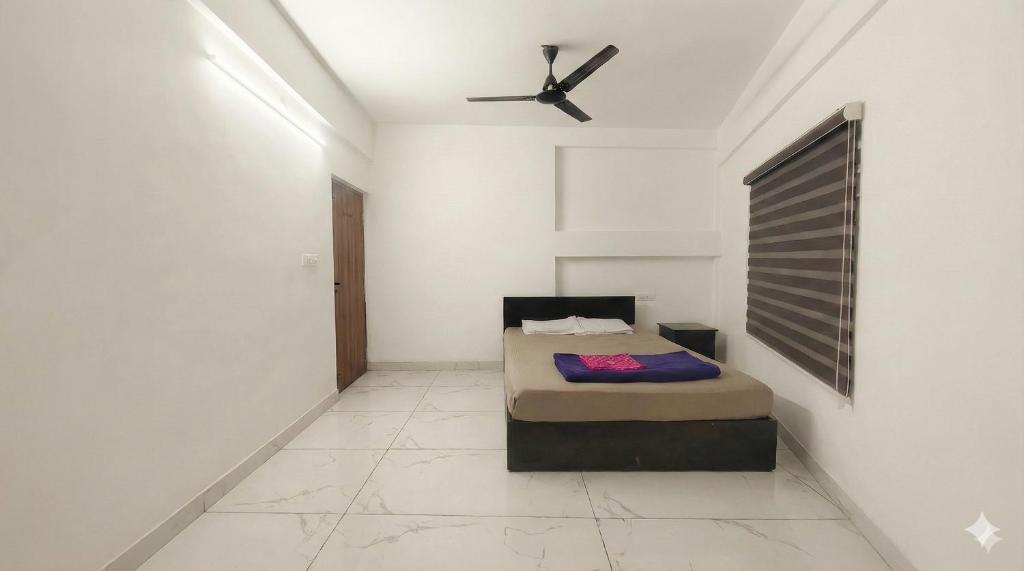 a bedroom with a bed and a ceiling fan at SAIS LINE Residency in Kozhikode