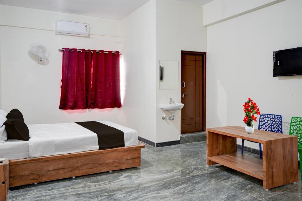 Hotel O Jodi Sri Muneshwara Swamy Temple في Jālahalli: غرفة نوم بها سرير وستارة حمراء