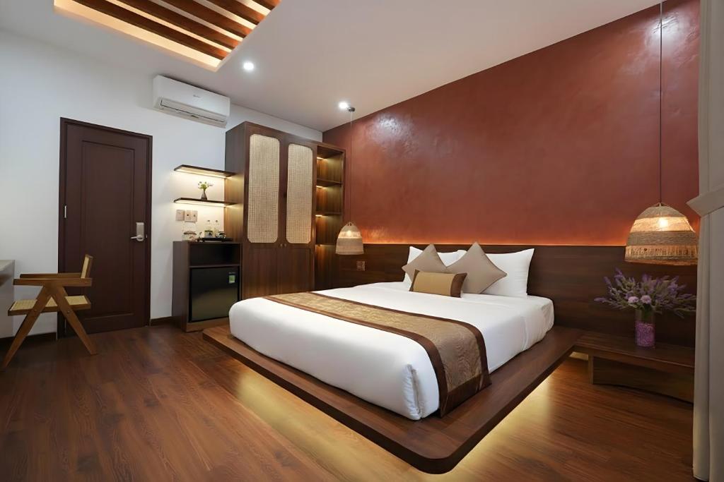a bedroom with a large white bed and a desk at Nana Villa Hue in Hue