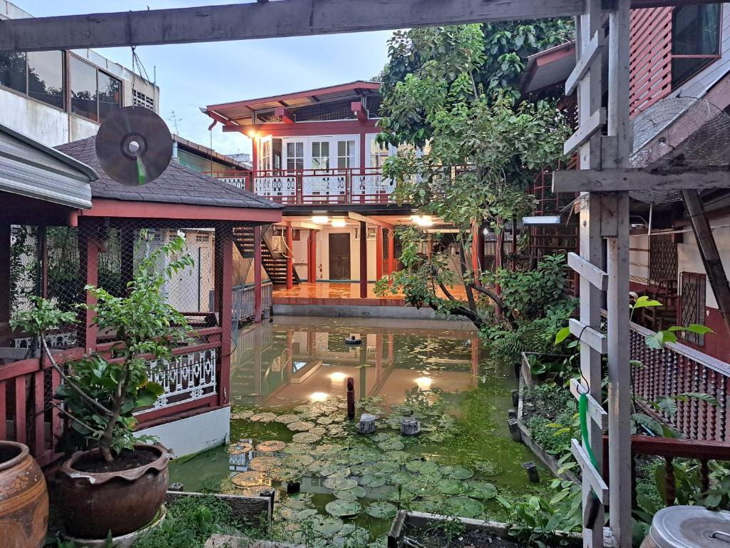 a house with a koi pond in the yard at Casa Scarlet in Bangkok