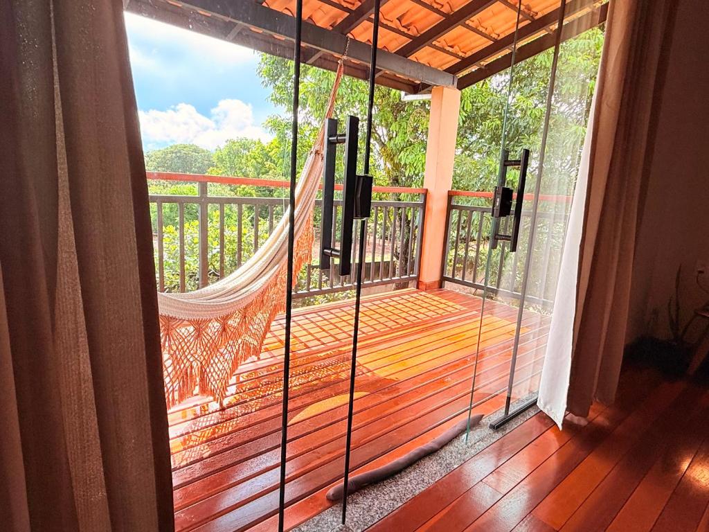 Claruá Chalés- Loft Baru - espaço romântico e tranquilo em Cavalcante في كافالكانتي: شرفة مع أرجوحة على السطح