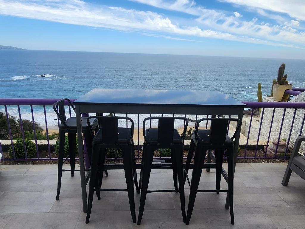a table and chairs on a balcony with the ocean at A pasos de Reñaca, Gran Vista in Viña del Mar