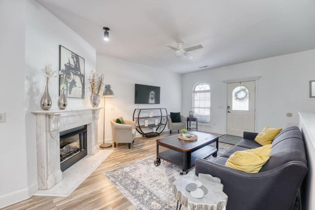 een woonkamer met een bank en een open haard bij Modern 4BR Retreat with Fire Pit in Bentonville