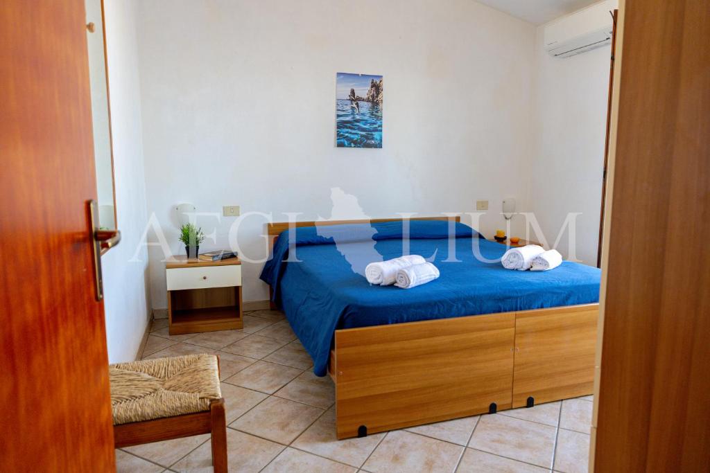 a bedroom with a blue bed with towels on it at Castello 4 in Isola del Giglio