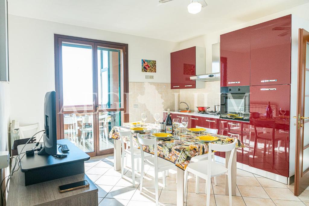 a kitchen with red cabinets and a table with chairs at Castello 9 in Isola del Giglio