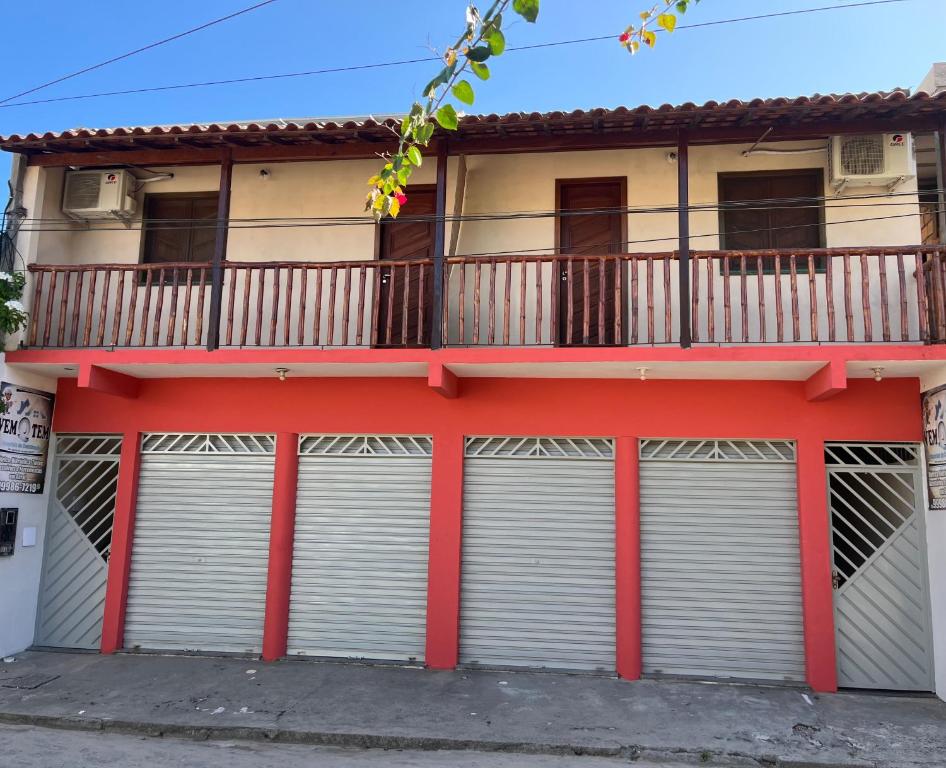 ein Gebäude mit zwei Garagentoren und einem Balkon in der Unterkunft Caminho das praias - Boipeba in Ilha de Boipeba