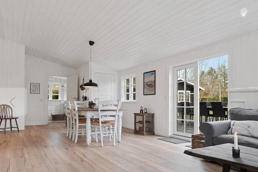 a kitchen and living room with a table and chairs at Beach House Near Sejerø Bay in Hønsinge
