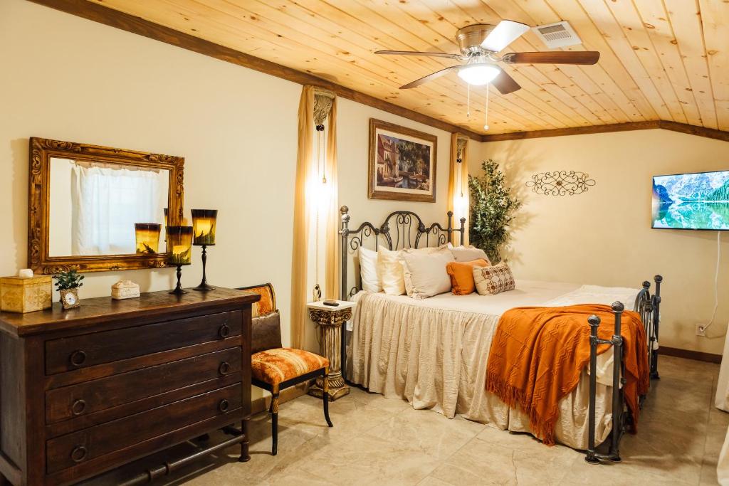 een slaapkamer met een bed, een spiegel en een dressoir bij Escape to Villa Serena - with a Hidden Speakeasy in Dahlonega