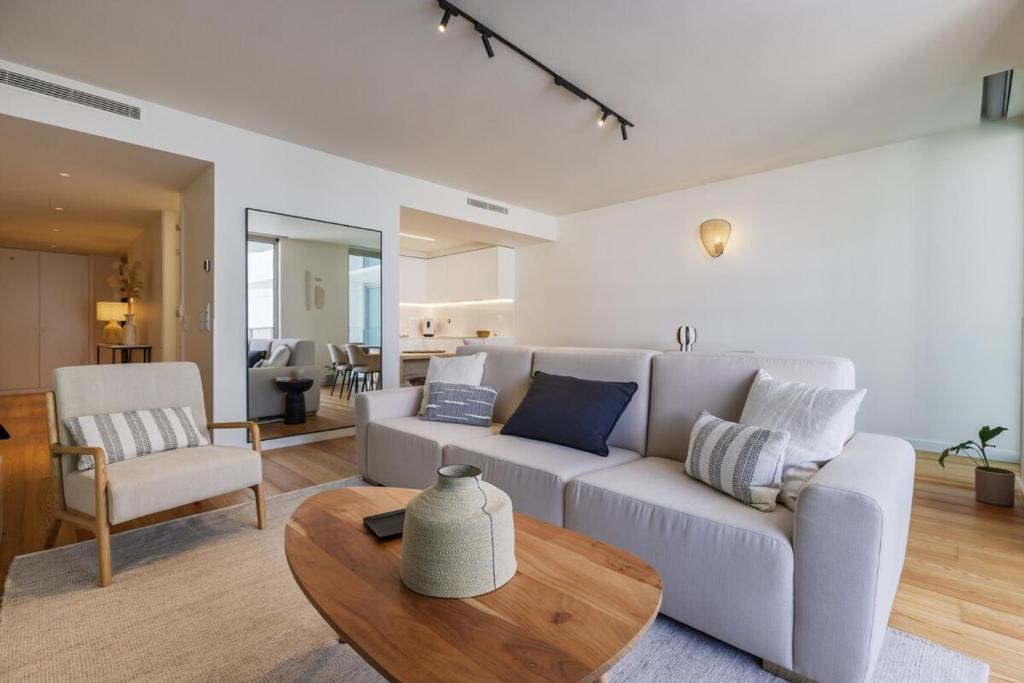 a living room with a white couch and a table at Bayline Solaris 4 in Armação de Pêra